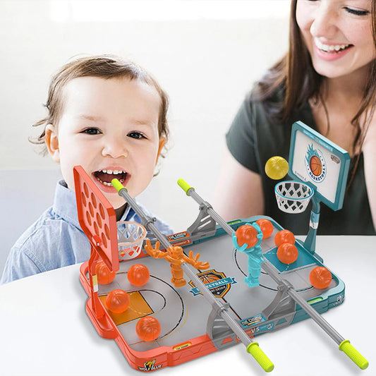 Child and adult playing with a toy basketball game on a table.